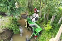 Un tractor s-a răsturnat într-un pârâu, șoferul a rămas blocat în cabină